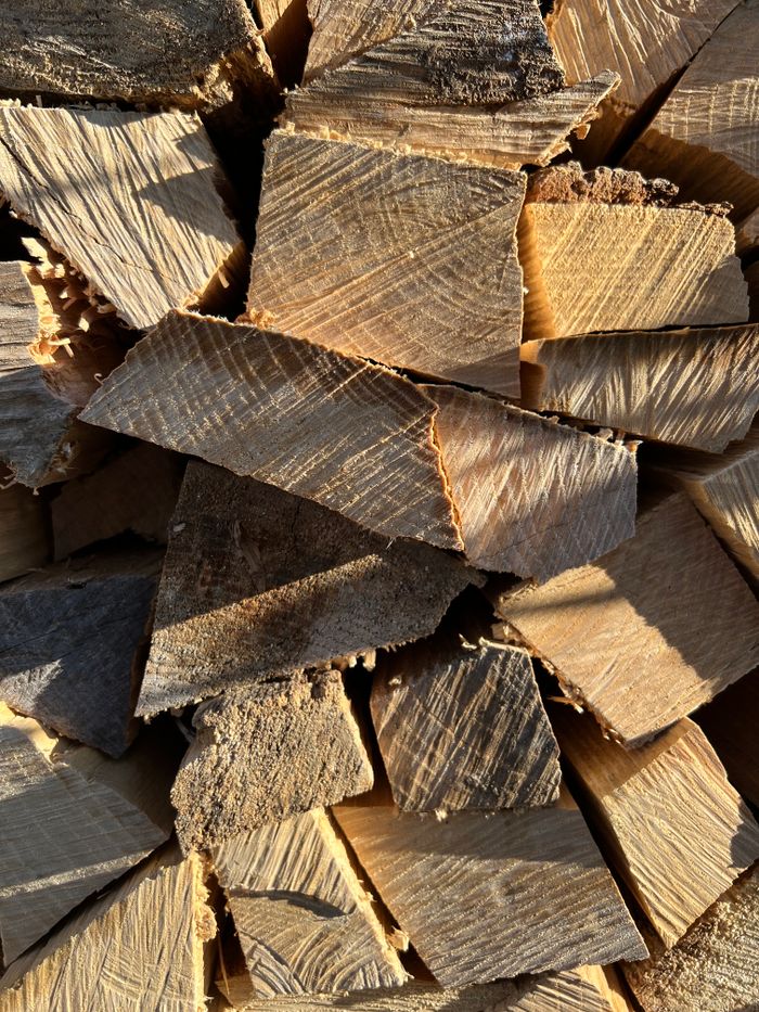 Close-up view of stacked firewood logs showcasing their distinct natural textures and patterns.