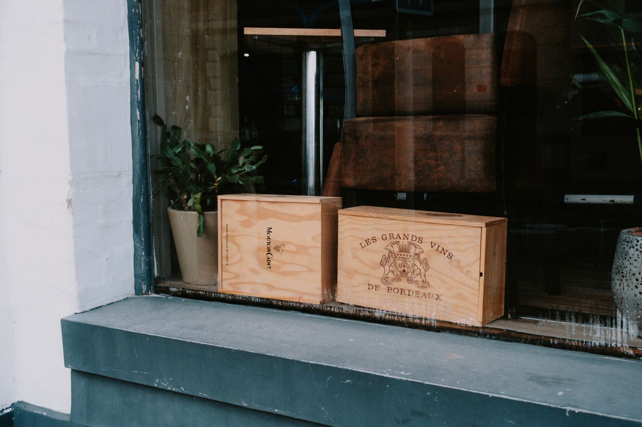 Wooden wine crates displayed in a shop window, showcasing rustic charm and vintage appeal.